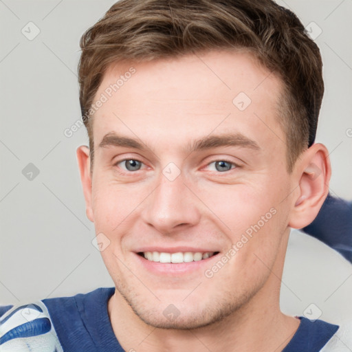 Joyful white young-adult male with short  brown hair and grey eyes