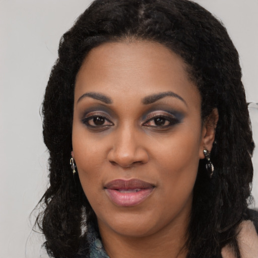 Joyful black young-adult female with long  black hair and brown eyes