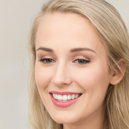 Joyful white young-adult female with long  brown hair and blue eyes