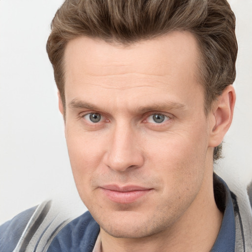 Joyful white adult male with short  brown hair and grey eyes