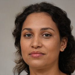 Joyful latino adult female with medium  brown hair and brown eyes