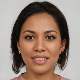 Joyful latino young-adult female with medium  brown hair and brown eyes