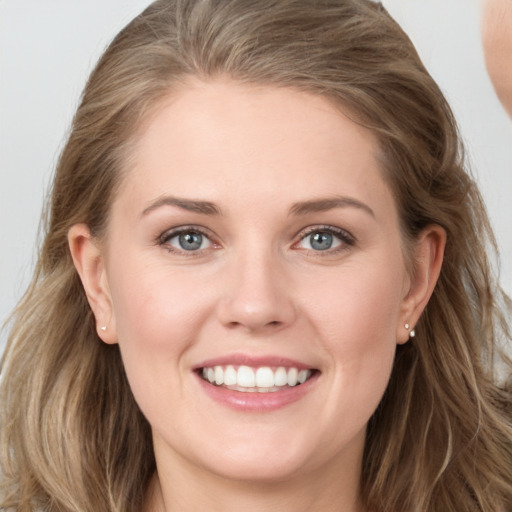 Joyful white young-adult female with long  brown hair and blue eyes