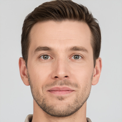 Joyful white young-adult male with short  brown hair and grey eyes