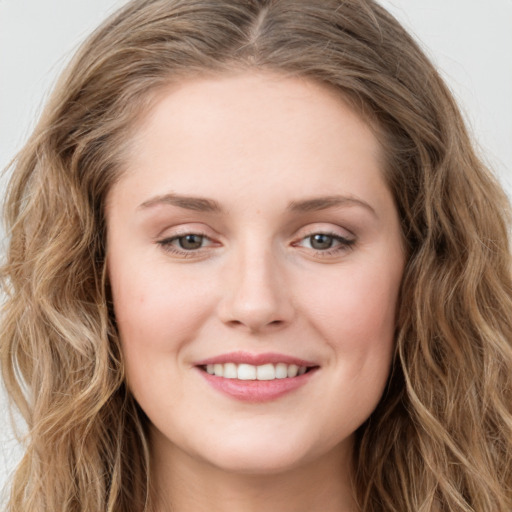 Joyful white young-adult female with long  brown hair and green eyes