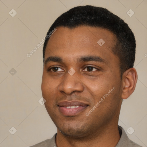 Joyful black young-adult male with short  black hair and brown eyes