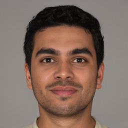 Joyful latino young-adult male with short  brown hair and brown eyes