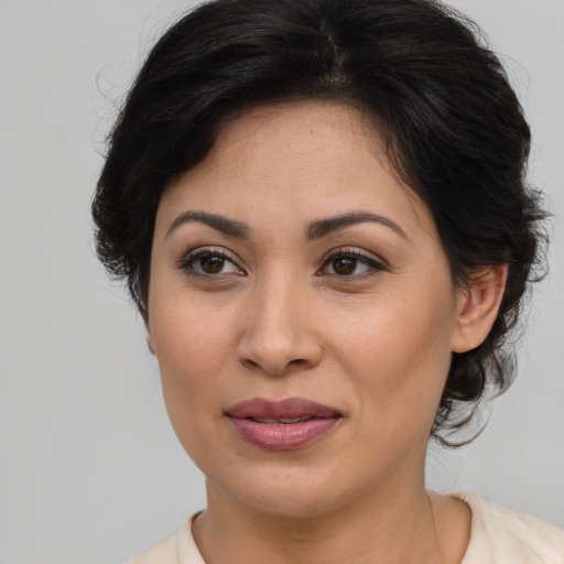 Joyful latino adult female with medium  brown hair and brown eyes
