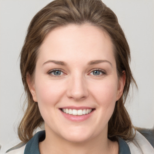 Joyful white young-adult female with medium  brown hair and grey eyes