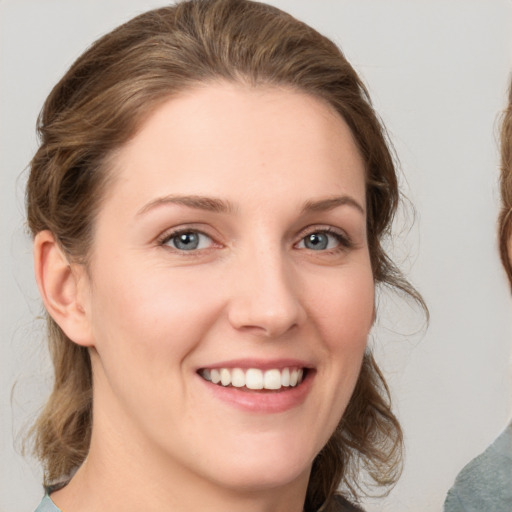 Joyful white young-adult female with medium  brown hair and grey eyes