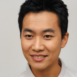 Joyful asian young-adult male with short  black hair and brown eyes