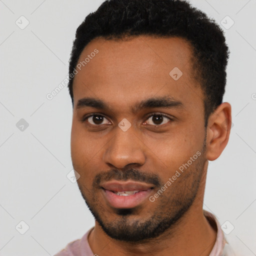 Joyful black young-adult male with short  black hair and brown eyes