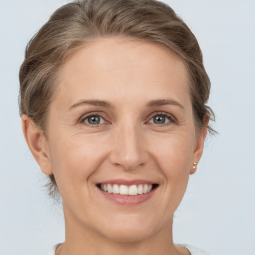 Joyful white young-adult female with short  brown hair and grey eyes