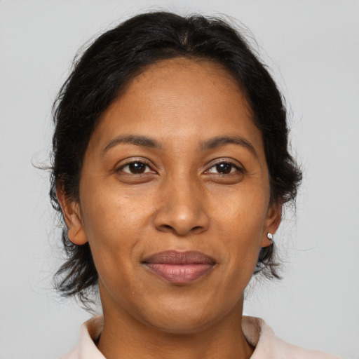 Joyful black adult female with medium  brown hair and brown eyes