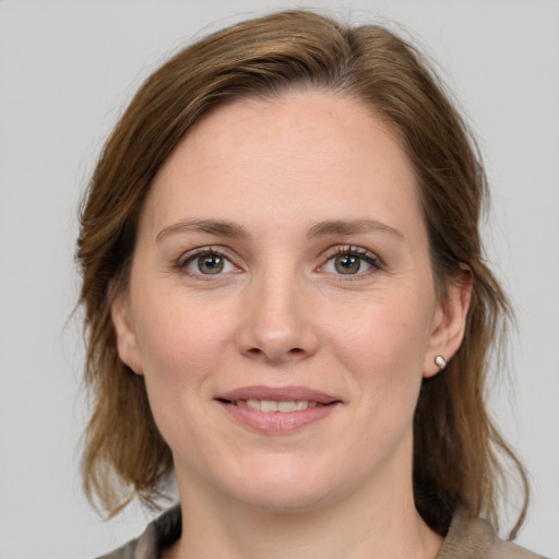 Joyful white young-adult female with medium  brown hair and grey eyes