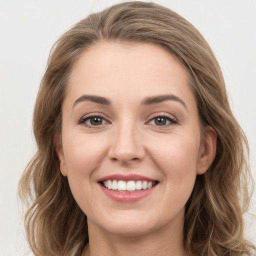 Joyful white young-adult female with long  brown hair and grey eyes