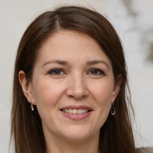 Joyful white adult female with long  brown hair and brown eyes