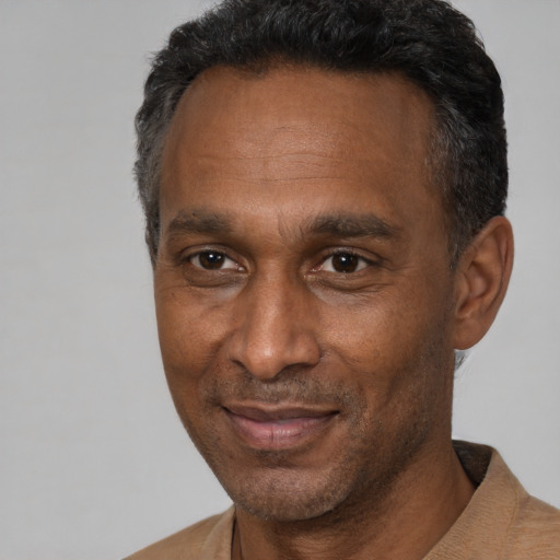 Joyful black adult male with short  black hair and brown eyes