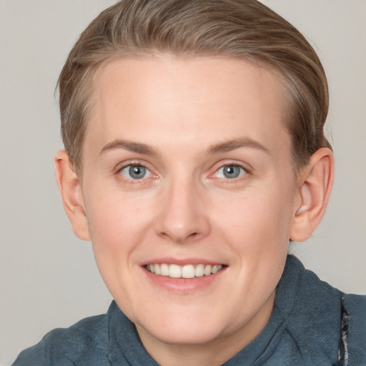 Joyful white adult female with short  brown hair and blue eyes