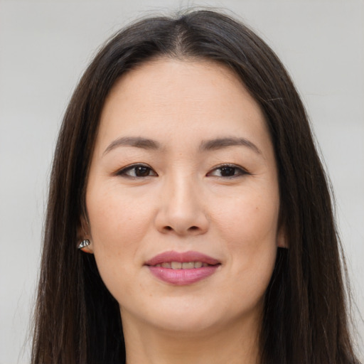 Joyful asian young-adult female with long  brown hair and brown eyes