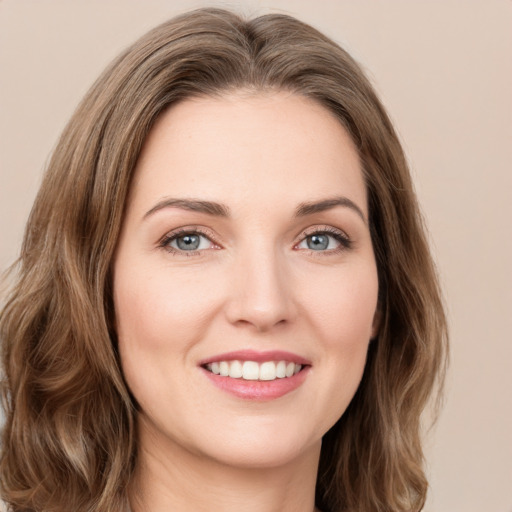 Joyful white young-adult female with long  brown hair and green eyes