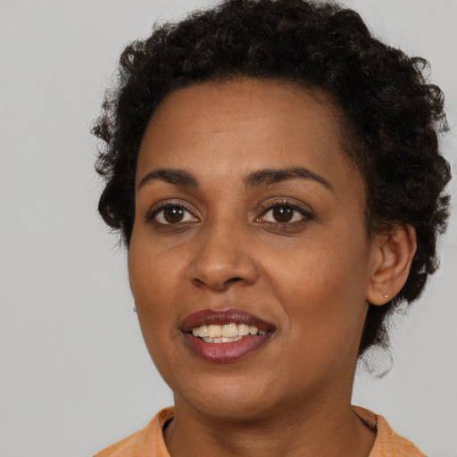 Joyful black adult female with short  brown hair and brown eyes