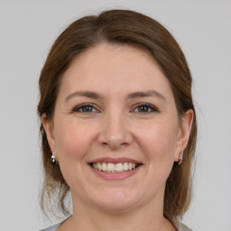 Joyful white young-adult female with medium  brown hair and grey eyes