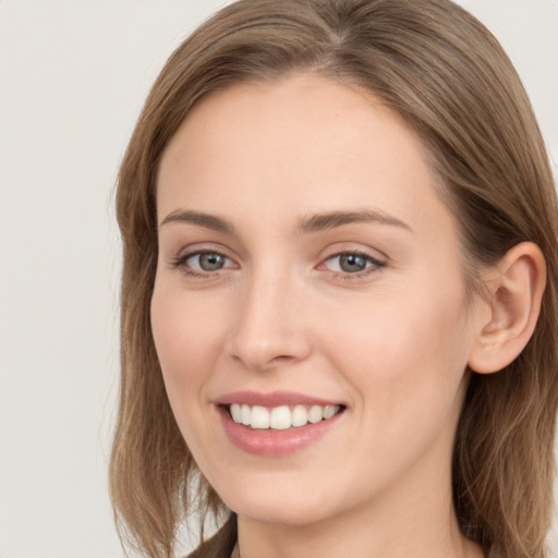 Joyful white young-adult female with long  brown hair and grey eyes