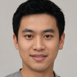 Joyful asian young-adult male with short  black hair and brown eyes