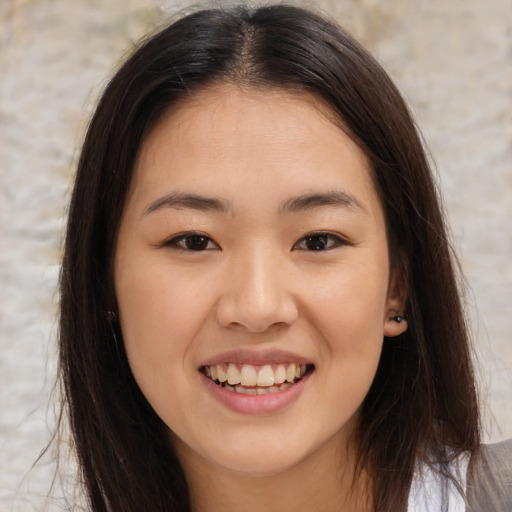 Joyful asian young-adult female with long  brown hair and brown eyes