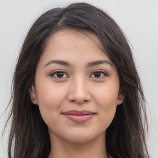 Joyful latino young-adult female with long  brown hair and brown eyes