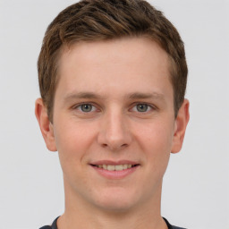 Joyful white young-adult male with short  brown hair and grey eyes