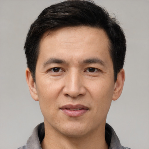 Joyful asian adult male with short  black hair and brown eyes
