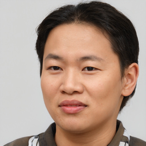Joyful asian young-adult male with short  brown hair and brown eyes