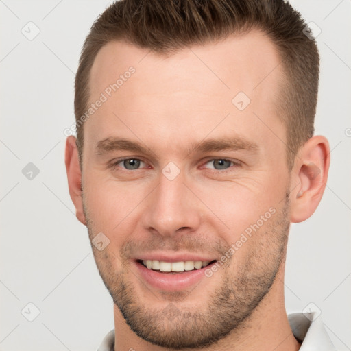 Joyful white young-adult male with short  brown hair and grey eyes