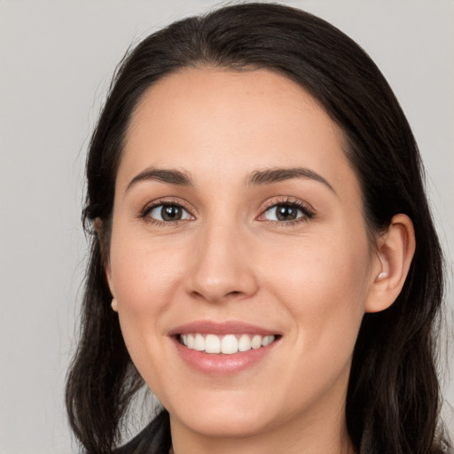 Joyful white young-adult female with long  brown hair and brown eyes