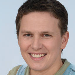 Joyful white adult male with short  brown hair and blue eyes