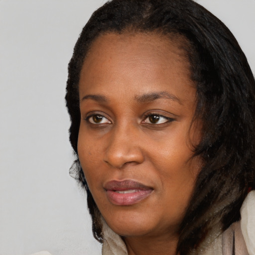 Joyful black adult female with long  black hair and brown eyes