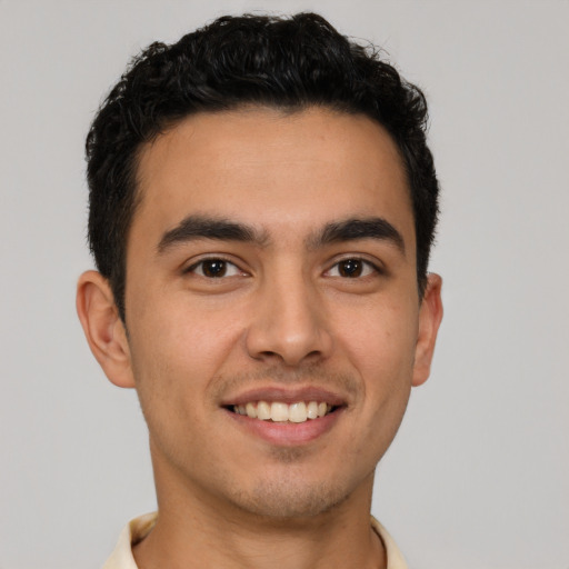 Joyful latino young-adult male with short  brown hair and brown eyes