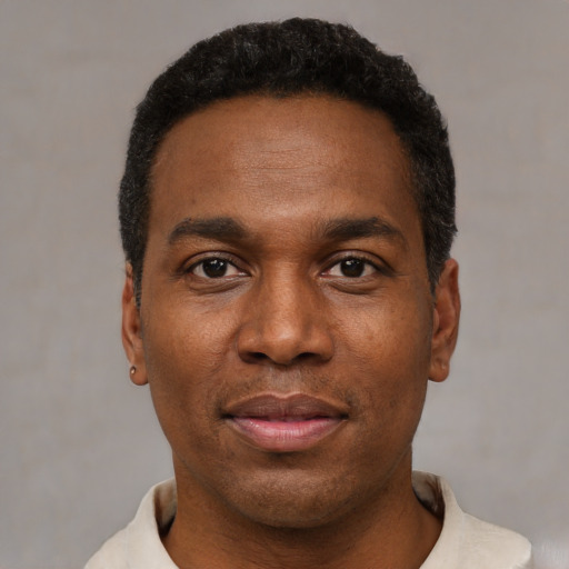Joyful black young-adult male with short  black hair and brown eyes