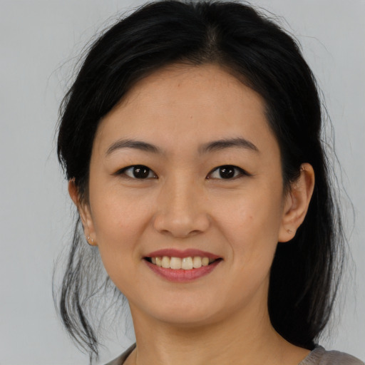 Joyful asian young-adult female with medium  black hair and brown eyes