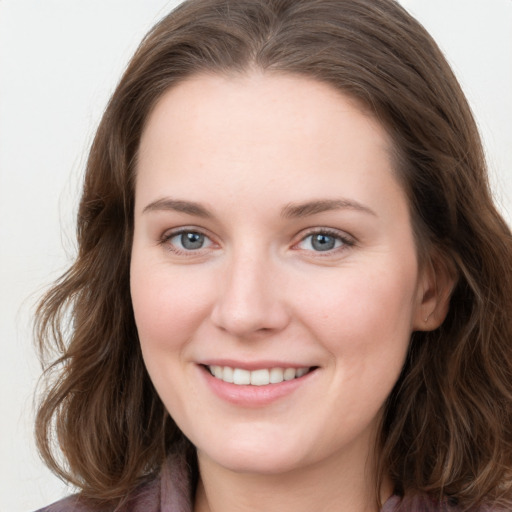 Joyful white young-adult female with long  brown hair and blue eyes