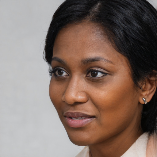 Joyful black young-adult female with medium  black hair and brown eyes