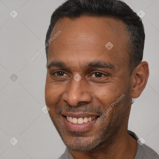 Joyful black adult male with short  black hair and brown eyes