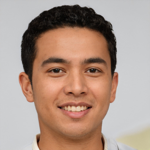 Joyful latino young-adult male with short  brown hair and brown eyes