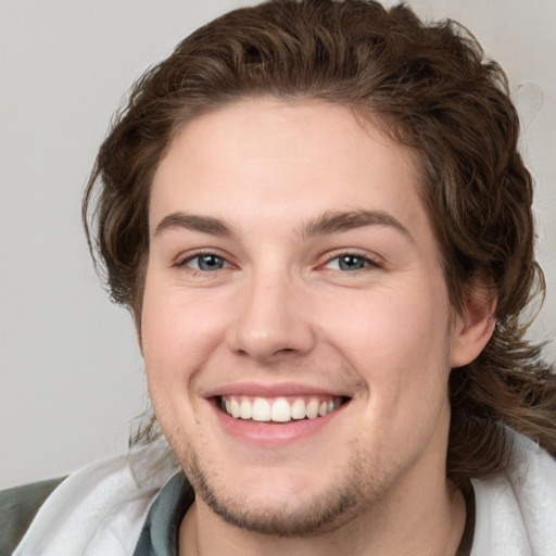 Joyful white young-adult male with medium  brown hair and brown eyes