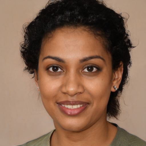 Joyful black young-adult female with medium  brown hair and brown eyes