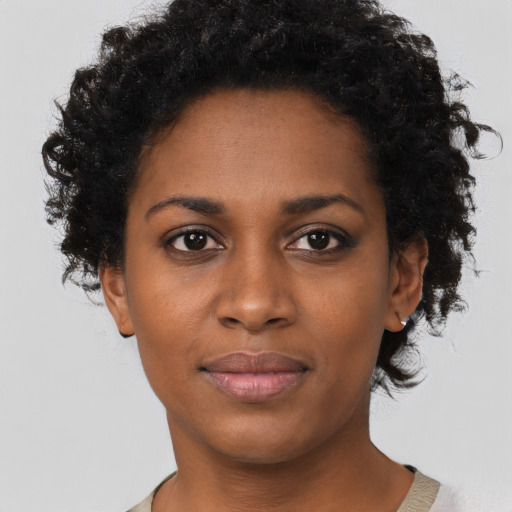 Joyful black young-adult female with short  black hair and brown eyes