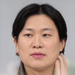 Joyful asian adult female with medium  brown hair and brown eyes