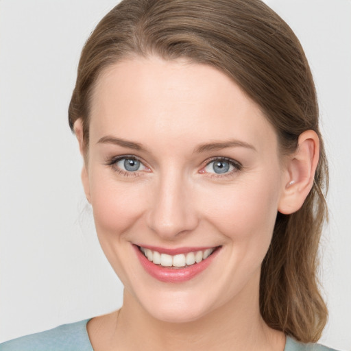 Joyful white young-adult female with medium  brown hair and grey eyes